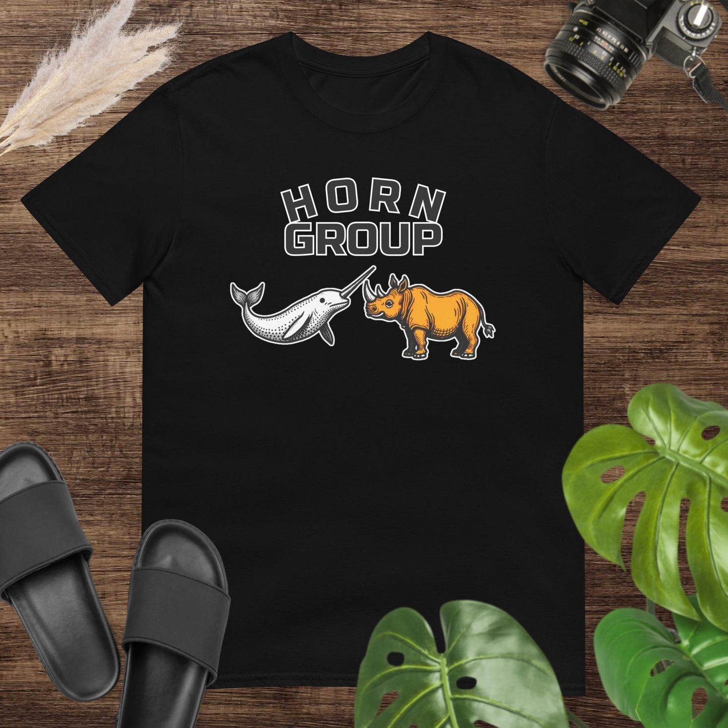 Unisex black t-shirt featuring a narwhal and a rhinoceros with the words “HORN Group.”