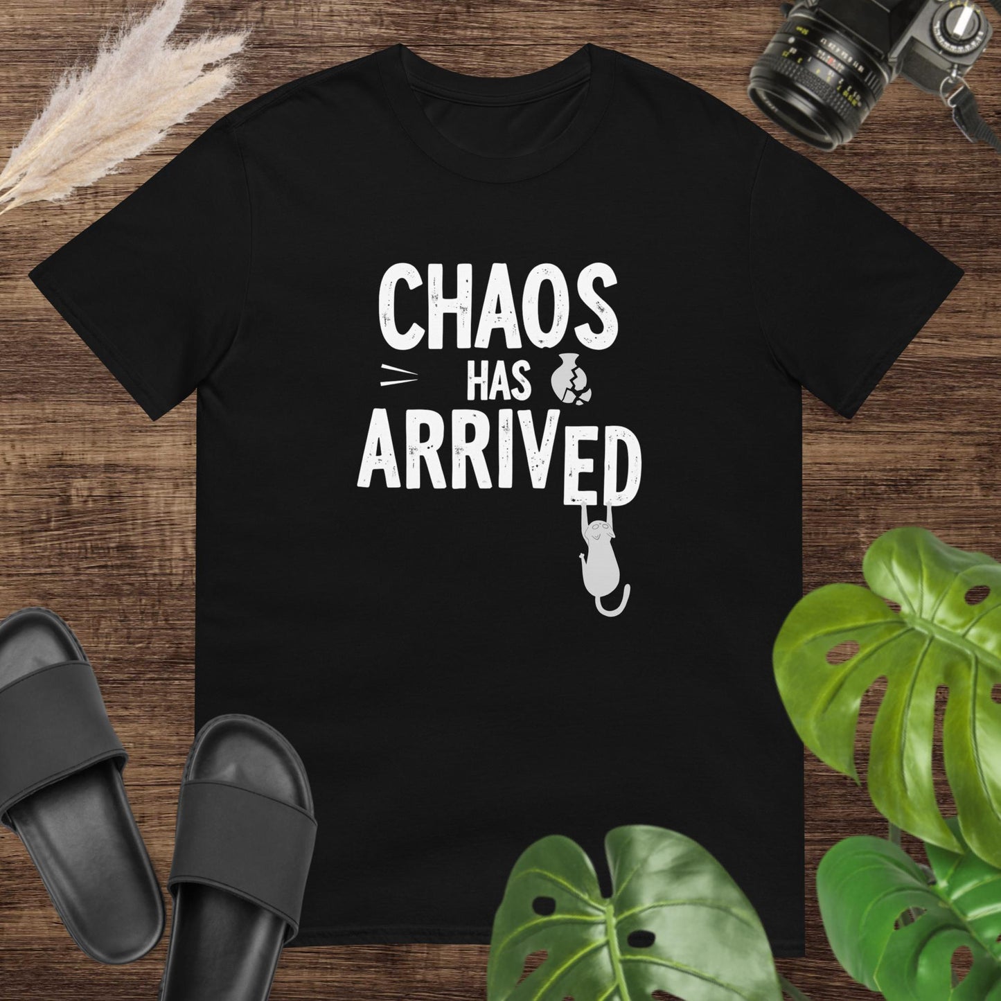 Funny black t-shirt featuring a cat breaking the word arrived in the text chaos has arrived