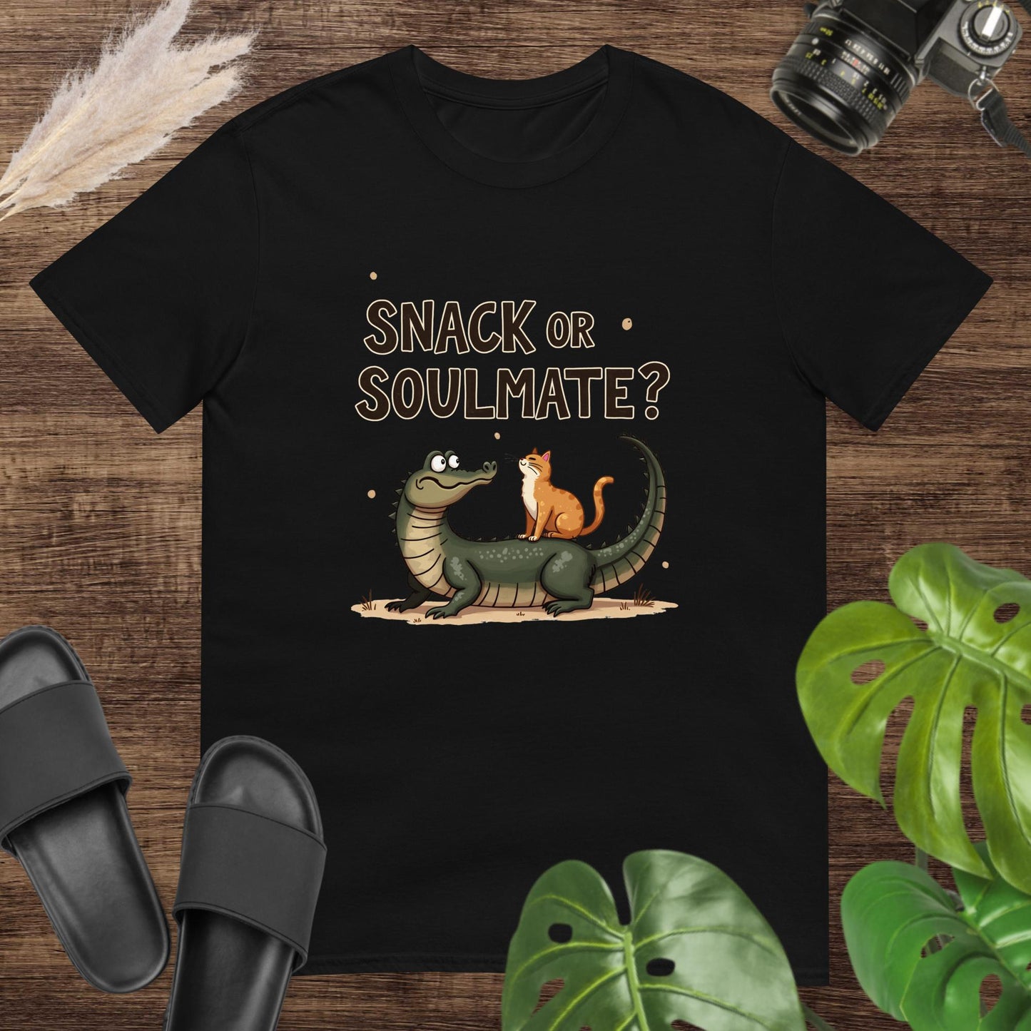 Unisex black t-shirt featuring a crocodile and cat with the text Snack or Soulmate?