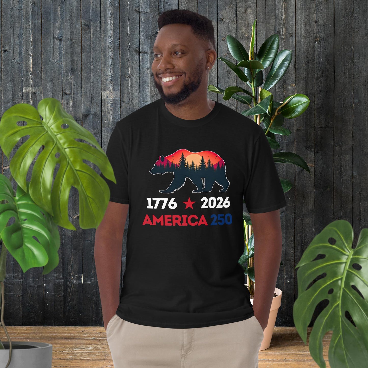 Man wearing black America 250 t-shirt with bear silhouette, forest, sunset, 1776-2026 design