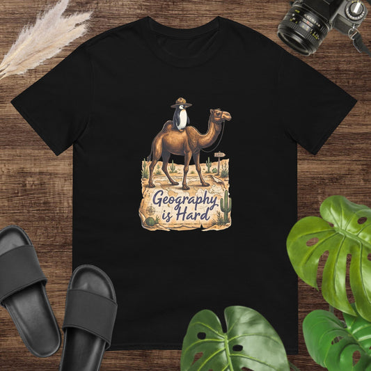 Unisex black t-shirt featuring a camel with a penguin on top and the text Geography is Hard.