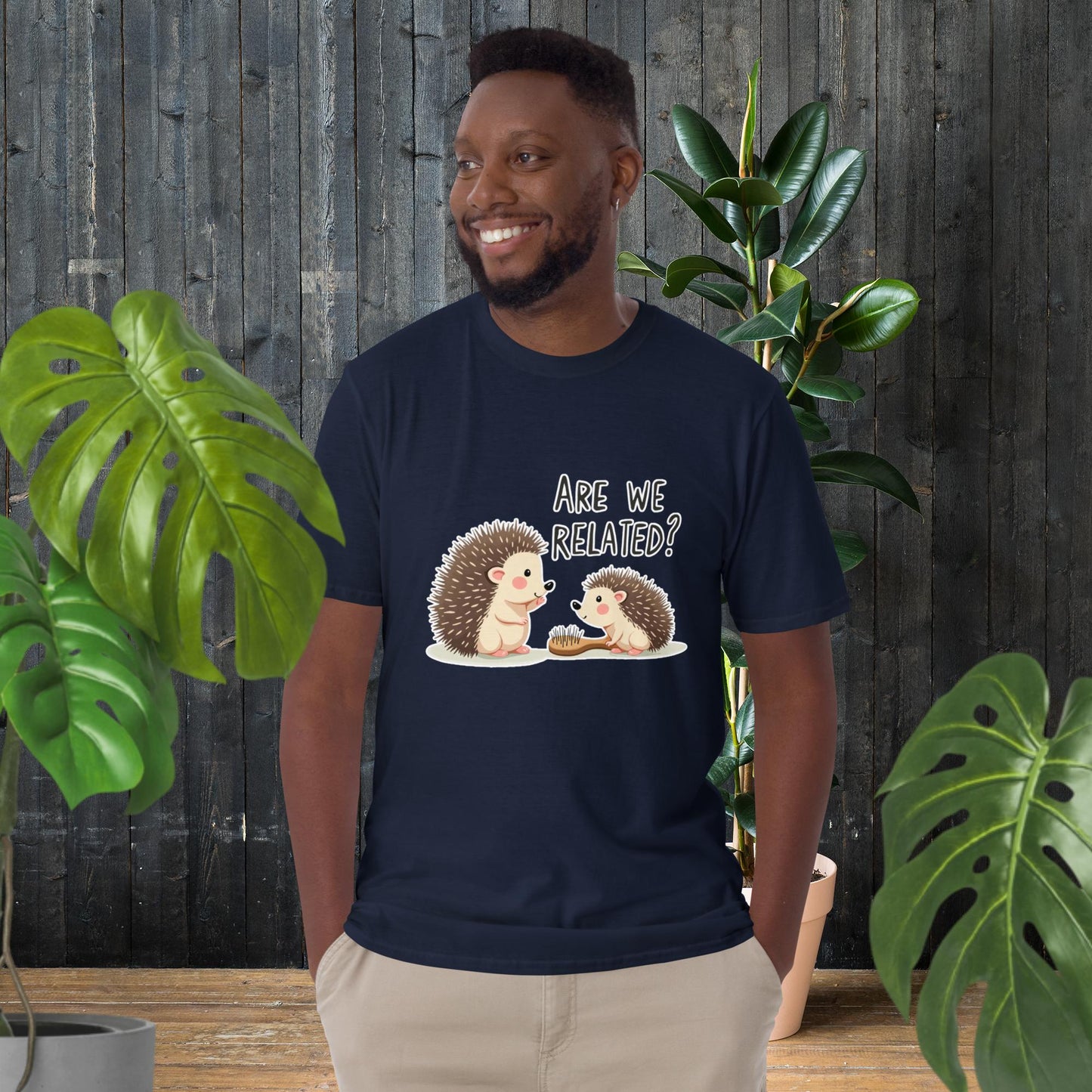 Man wearing navy t-shirt with cute hedgehog graphic saying 'Are We Related?' — funny animal duo design, unisex tee