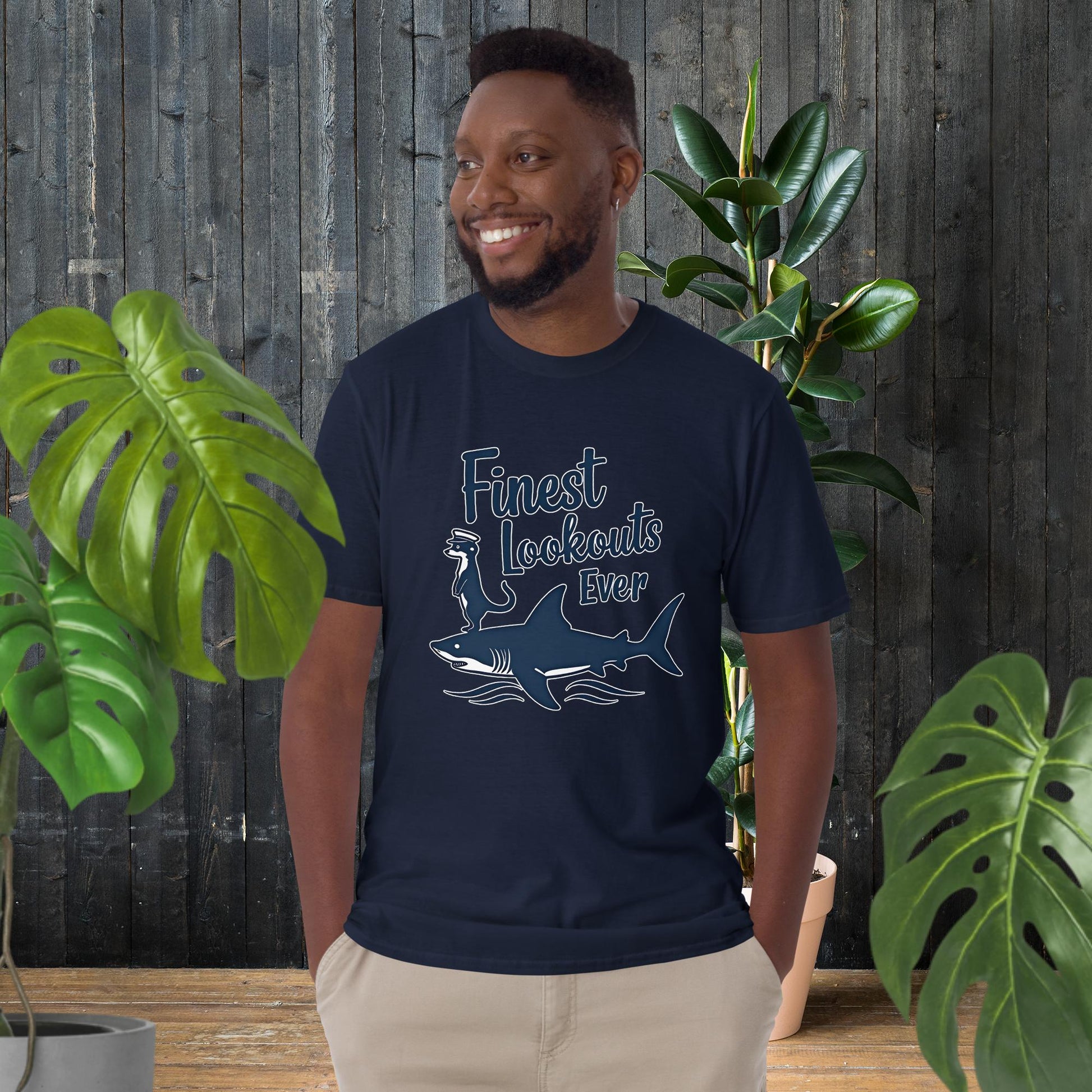 Man wearing navy t-shirt with shark and otter graphic, 'Finest Lookouts Ever,' 100% ring-spun cotton