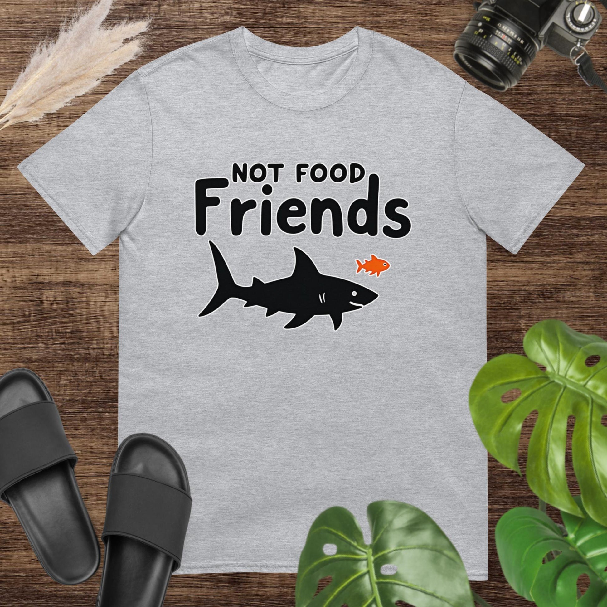 Grey t-shirt featuring a shark and a small fish with the words “NOT FOOD Friends.”