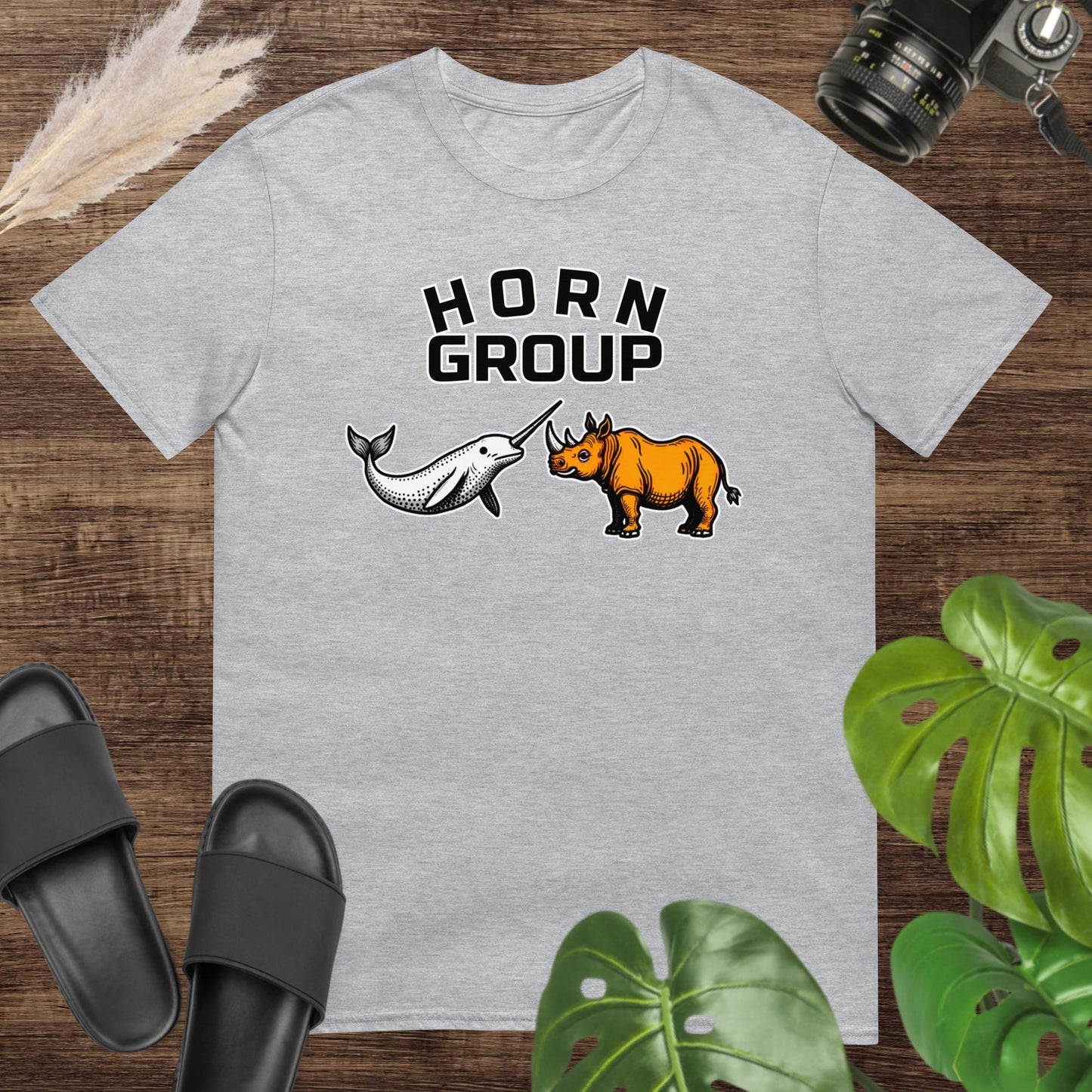 Unisex grey t-shirt featuring a narwhal and a rhinoceros with the words “HORN Group.”