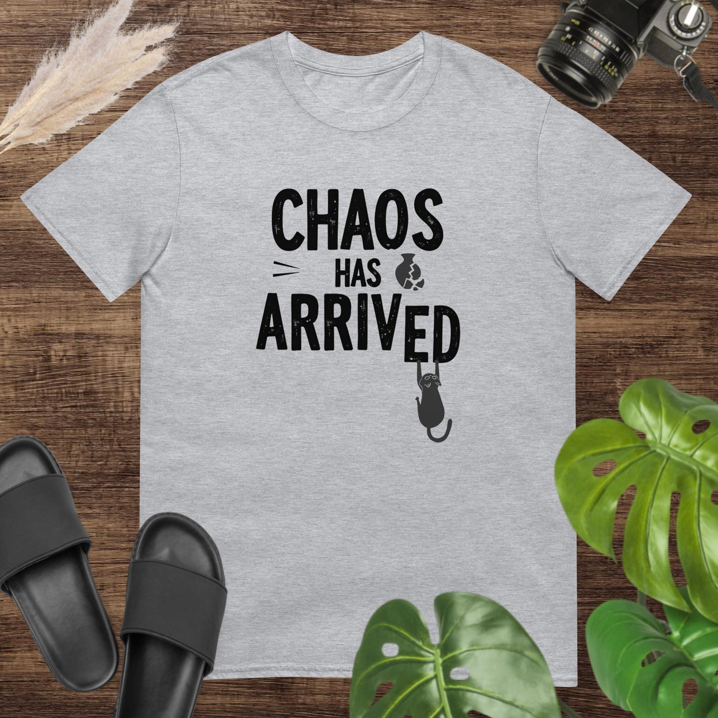 Funny grey t-shirt featuring a cat breaking the word arrived in the text chaos has arrived