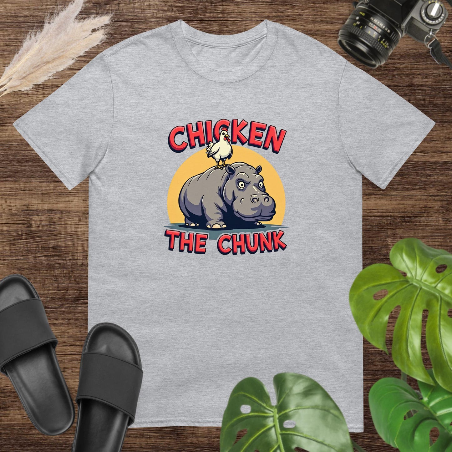 Unisex grey t-shirt featuring a chicken standing on a hippo with the text Chicken the Chunk.