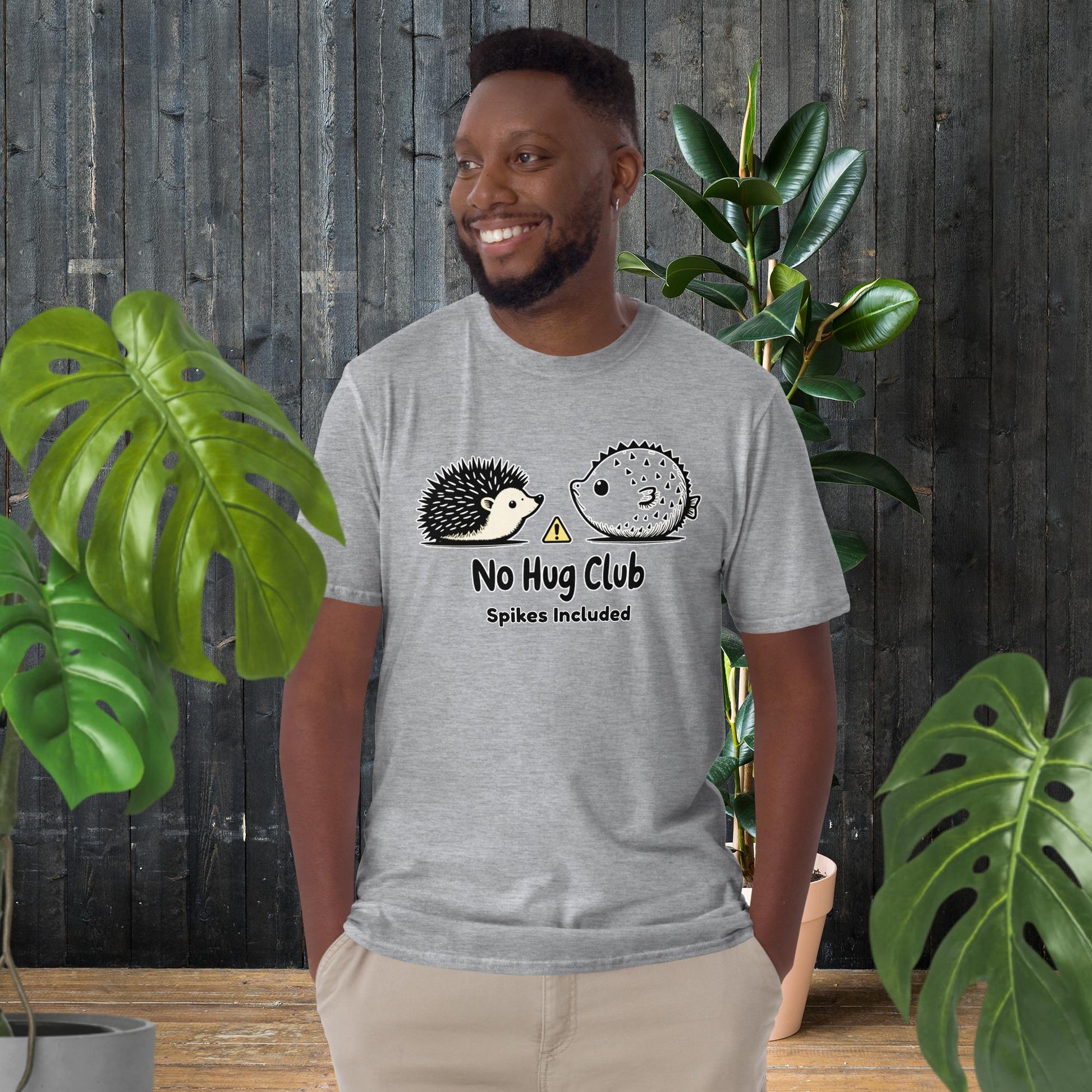 Man wearing funny unisex tee with hedgehog and pufferfish 'No Hug Club' graphic, perfect for pet lovers.