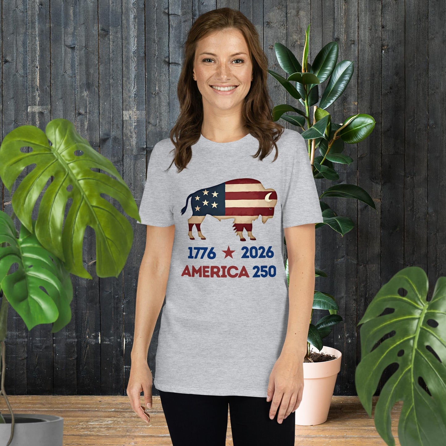Woman wearing gray t-shirt with American flag bison graphic, '1776 2026 America 250' text, unisex patriotic tee