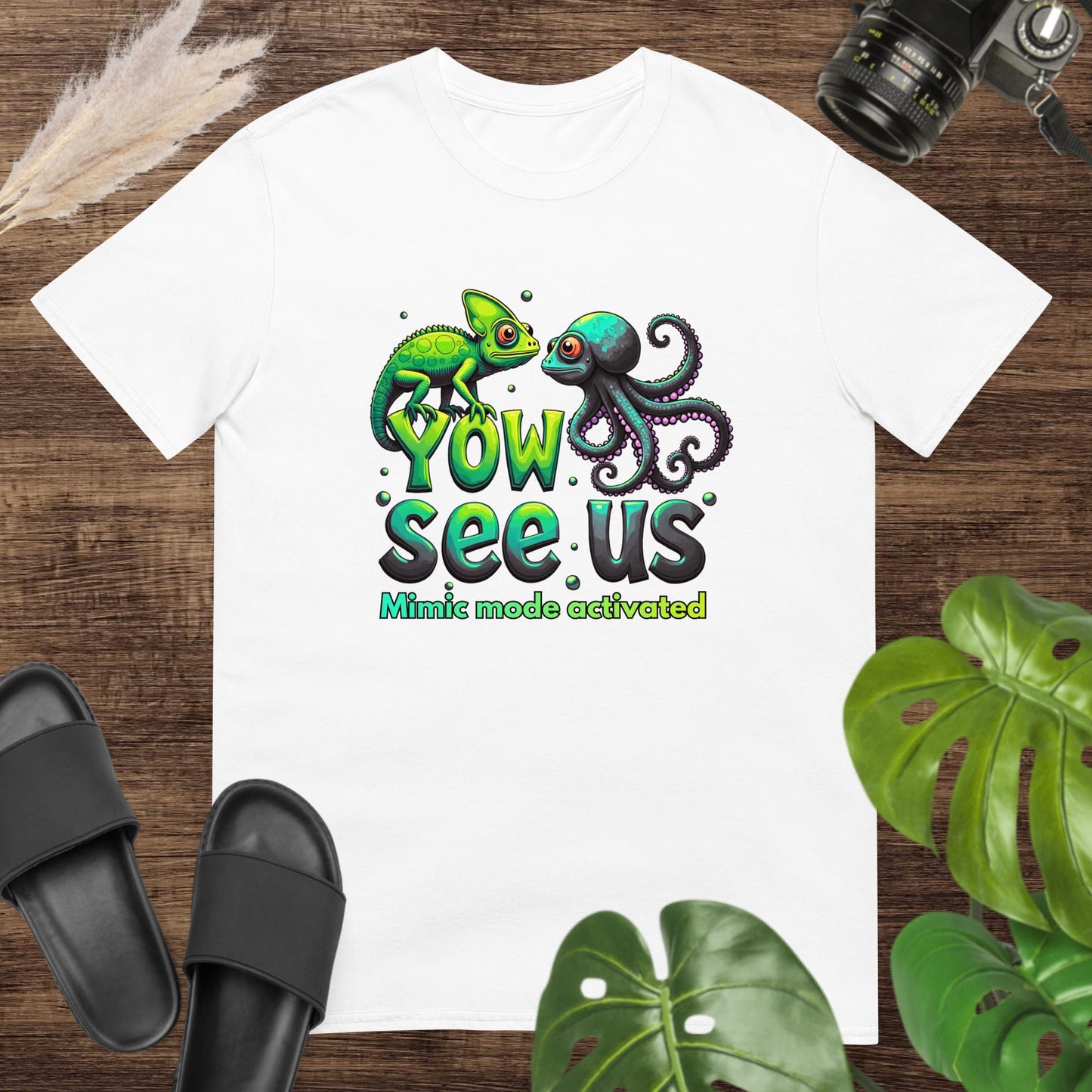 White t-shirt featurung a chameleon and an octopus shirt with the text "Yow see us. Mimic mode activated"