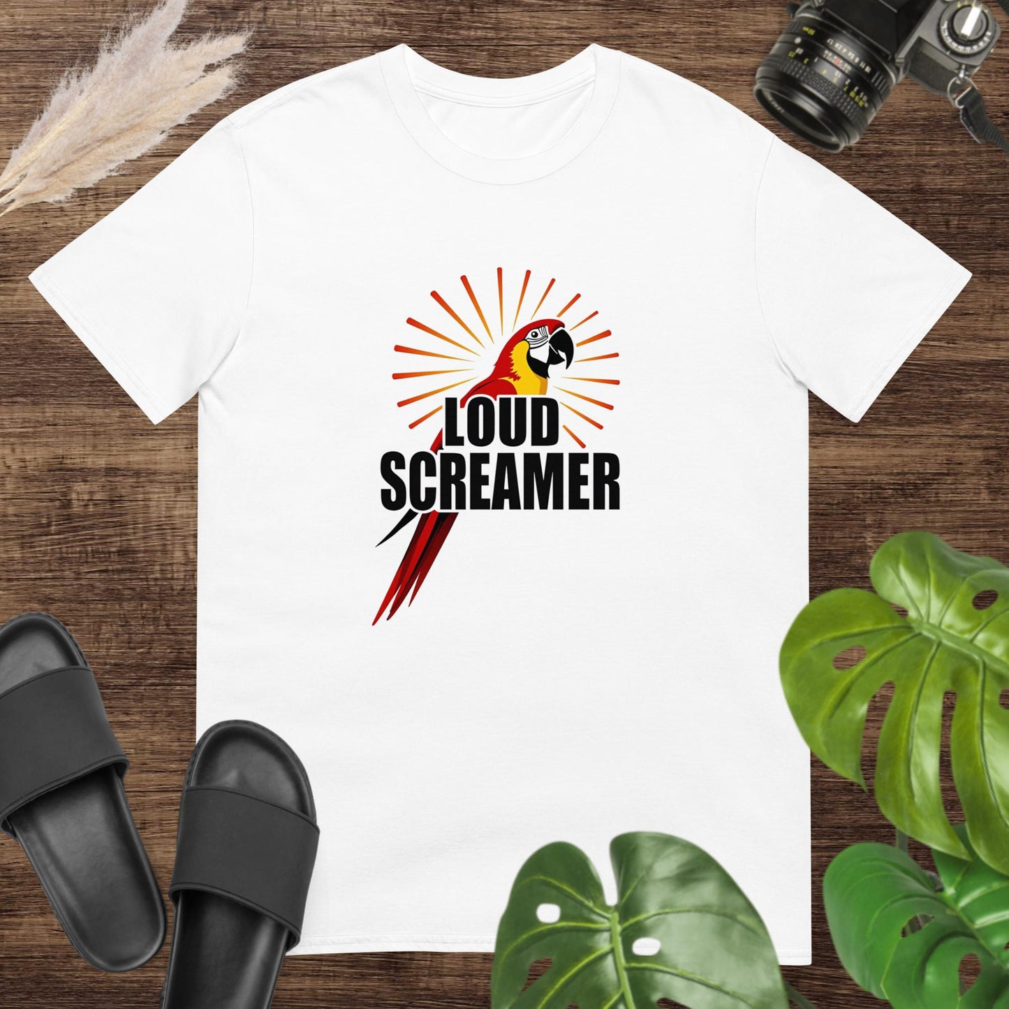 White t-shirt featuring a colorful parrot with the words “LOUD SCREAMER” and sunburst lines.